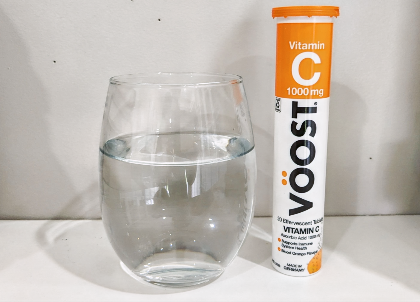 Voost electrolytes next to plain glass of water
