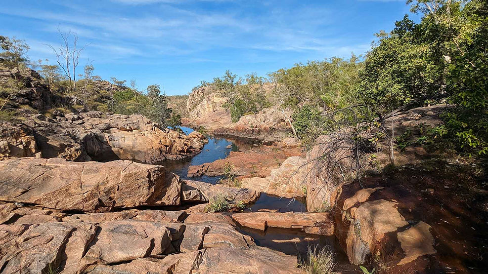 River flowing over large red boulders